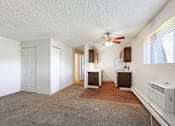 Thumbnail 7 of 12 - an empty living room with a ceiling fan and a kitchen at Golden Arms Apartments, Golden, CO 80401