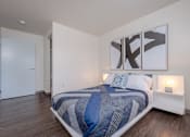 Thumbnail 4 of 9 - Bedroom in an apartment furnished with a queen-size bed, two nightstands, vinyl flooring, and high ceiling