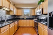 Thumbnail 16 of 40 - C shaped kitchen with black countertops and stainless steel appliances