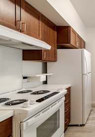 A kitchen with white appliances and wooden cabinets.