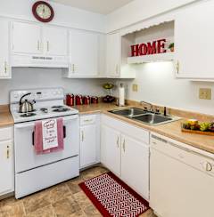 a kitchen with white appliances and white cabinets and a sink