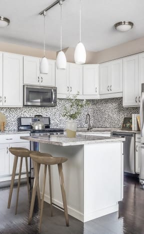 a large white kitchen with stainless steel appliances and a island