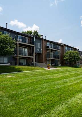A grassy area in front of apartment buildings.