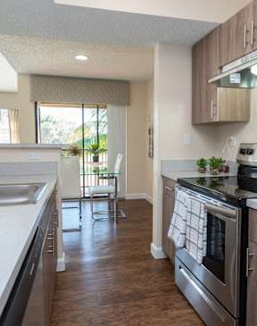 A kitchen with a stainless steel refrigerator, oven, and sink.