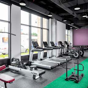 A gym with treadmills, weights, and exercise equipment.