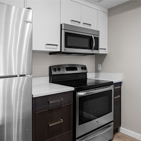 an empty kitchen with stainless steel appliances and a refrigerator