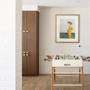 a dining room with a table with a chessboard and a painting on the wall