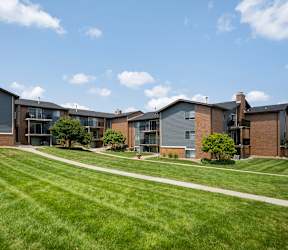 A row of modern houses with green lawns in front.