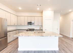 a white kitchen with a marble counter top