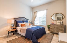 a bedroom with a bed and a dresser and a window at The Roseberry Apartments in Columbia, SC