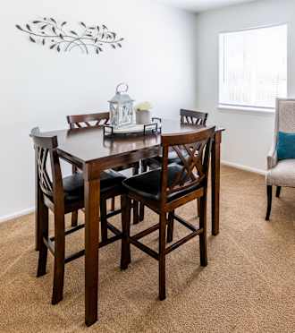 a dining room with a table and chairs and a window