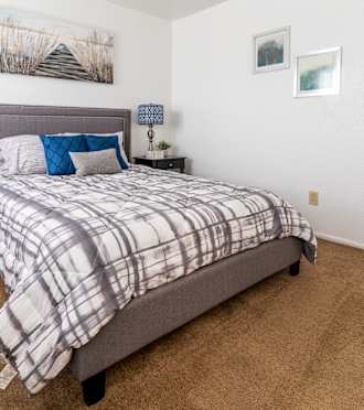 a bedroom with a bed and a dresser with a nightstand and a window