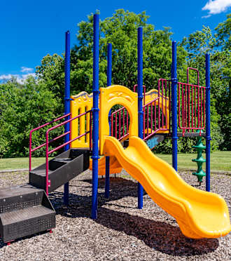 a playground with a yellow slide and other playground equipment