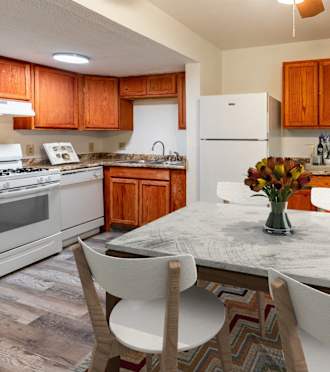 a kitchen with white appliances and a table with chairs