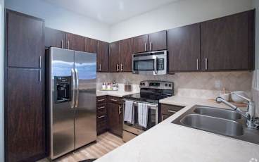 a kitchen with wooden cabinets and stainless steel appliances
