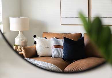 a living room with a couch with pillows and a lamp at Forge65, Iowa, 50327