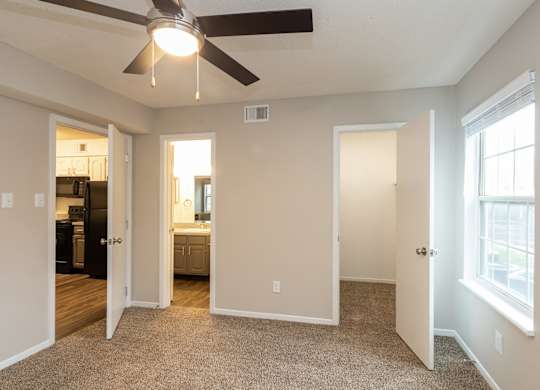 A room with a ceiling fan and a window.