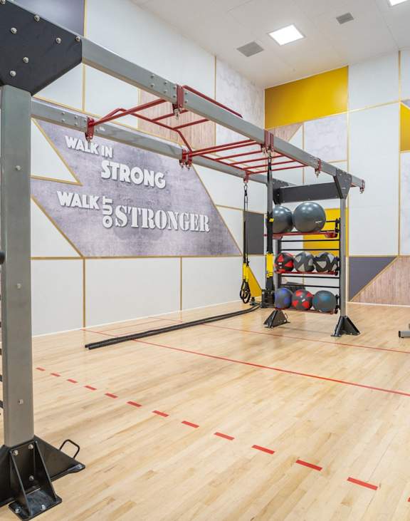 A gym with a sign that says "Walkin Strong" on the wall.