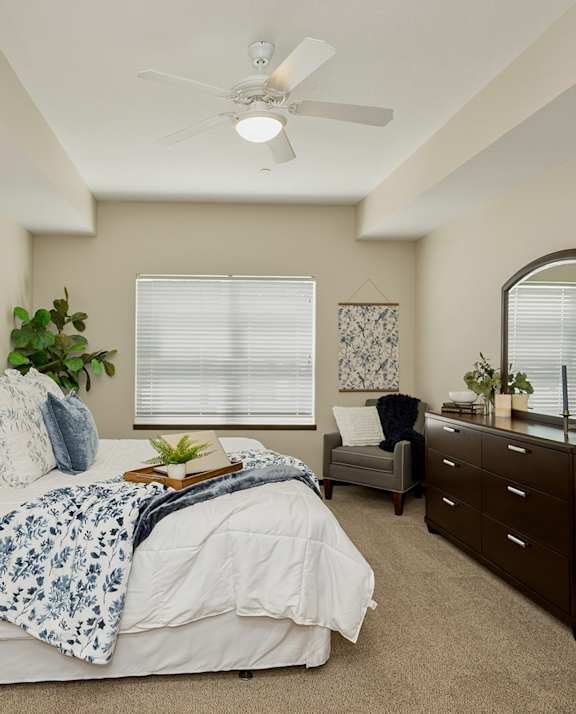 A bedroom with a large bed and a ceiling fan.