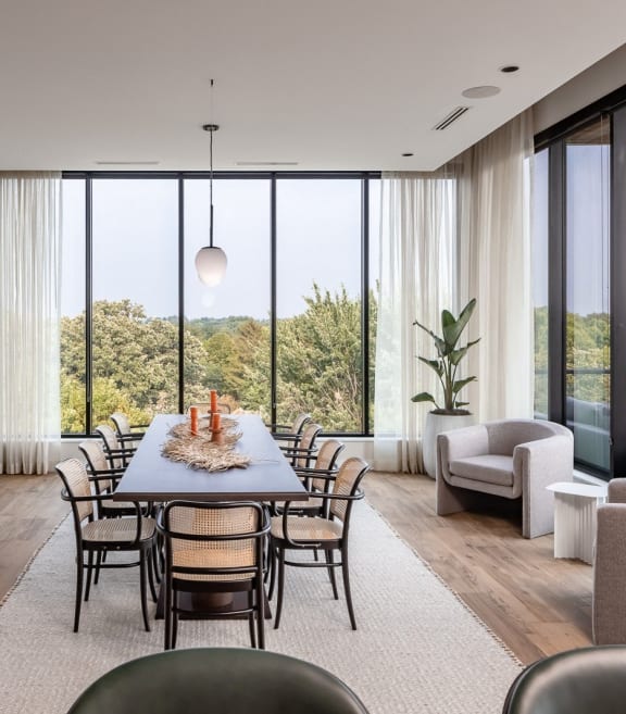 a dining room with a table and chairs and large windows
