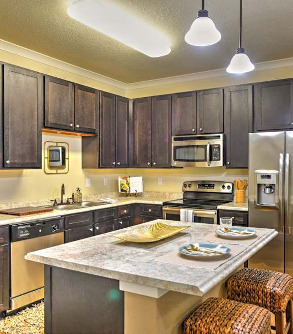 a kitchen with stainless steel appliances and a marble counter top