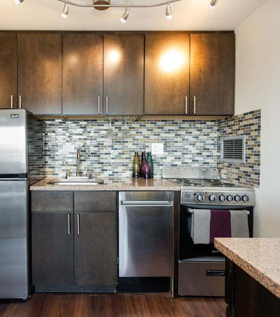 A kitchen with a stainless steel refrigerator, dishwasher, and oven.
