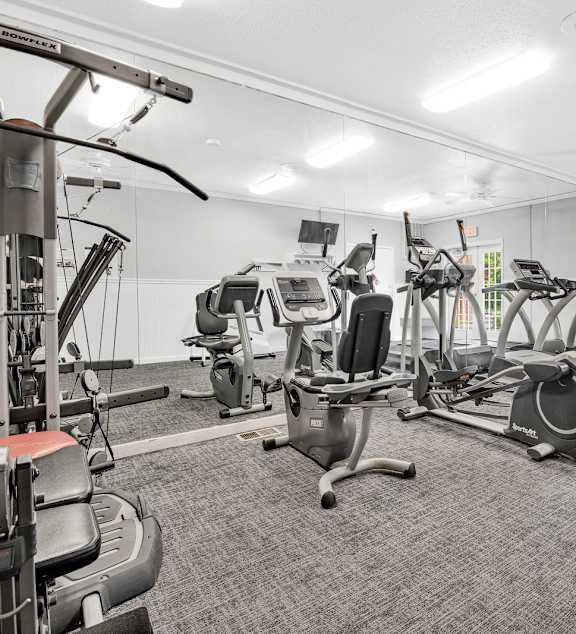 A gym with treadmills, elliptical machines, and other exercise equipment. at Kimberly Club Apartments, Iowa, 52807