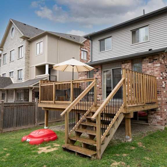 A house with a wooden deck and a red inflatable pool float.