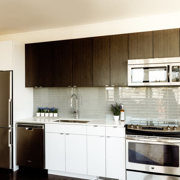 a kitchen with white cabinets and stainless steel appliances