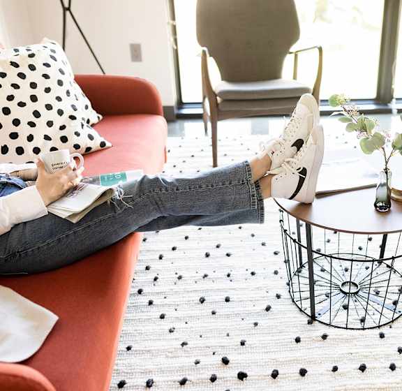 a woman sitting on a couch with her feet up on a coffee table