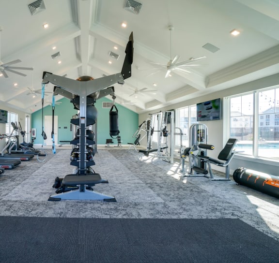 a gym with treadmills and other exercise equipment in a large room with windows