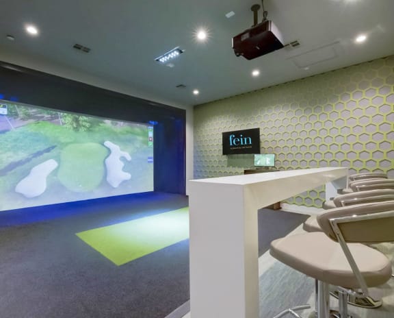 a room with bar stools and a projection screen on the wall