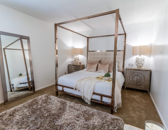 a bedroom with a white bed and a large mirror