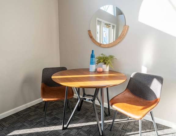a dining room with a table and chairs and a mirror
