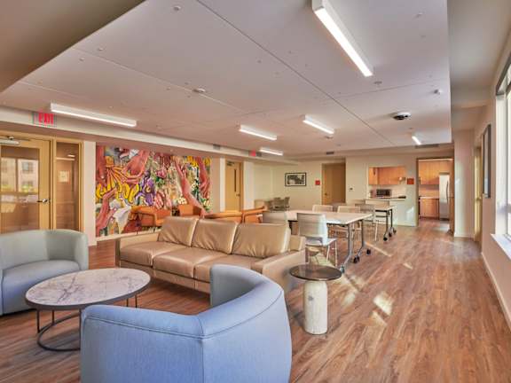 A room with a wooden floor and a large mural on the wall.
