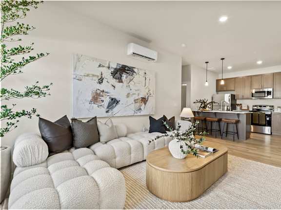 A modern living room with a white sofa and a wooden coffee table.