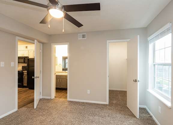 A room with a ceiling fan and a window.