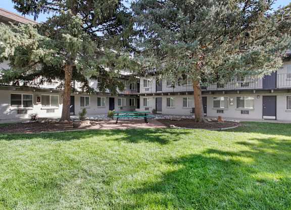 A grassy courtyard surrounded by apartment buildings. at Park at Fitzsimons Apartments, Aurora 80011