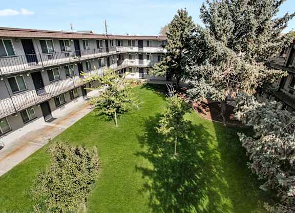 A grassy courtyard surrounded by apartment buildings. at Park at Fitzsimons Apartments, Colorado, 80011