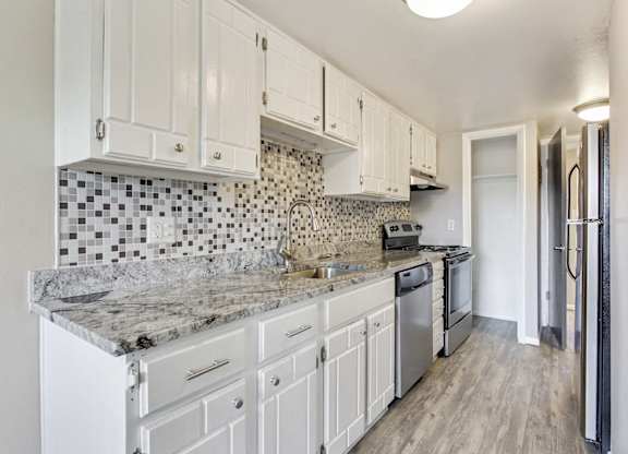 A kitchen with white cabinets and a marble countertop. at Park at Fitzsimons Apartments, Aurora, Colorado
