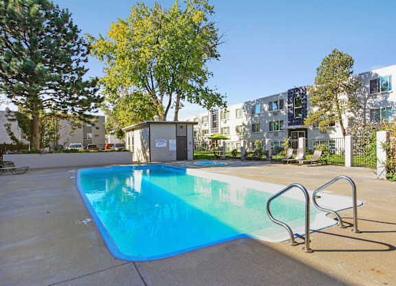 our apartments have a swimming pool with an apartment building in the background at Park at Fitzsimons Apartments, Aurora