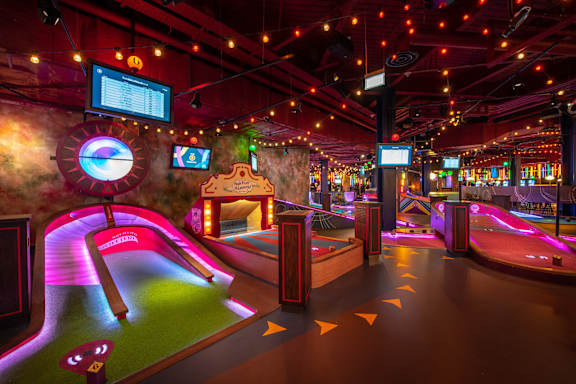 A miniature golf course with a neon sign that says "Kick Ass".