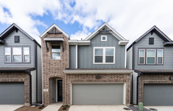 two story house with brick and gray siding and a garage
