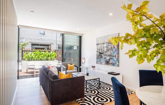 a living room with a green couch and a balcony