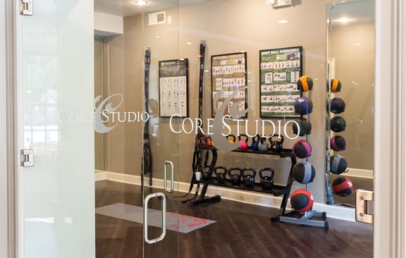 A gym with a glass wall and a sign that says Core Studio at The Atlantic Buckhead Apartments, Atlanta, GA, 30305