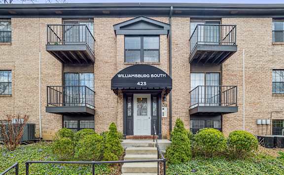 a brick apartment building with stairs and a blue door at Williamsburg South, Pennsylvania, 15228