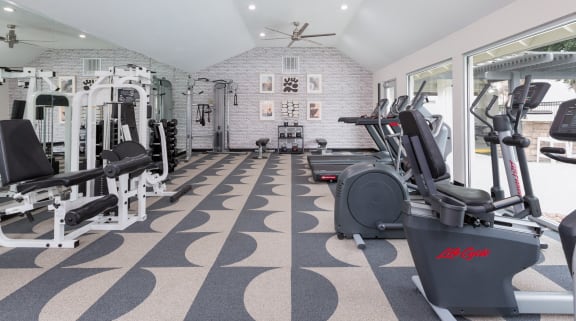 a gym with cardio machines and weights on the floor
