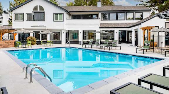 A large white house with a pool in the backyard.