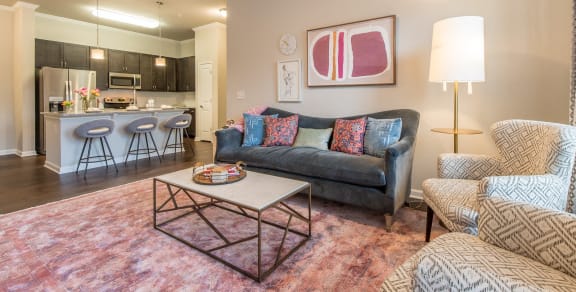 a living room with a couch and a coffee table in front of a kitchen at The Roseberry Apartments in Columbia, SC