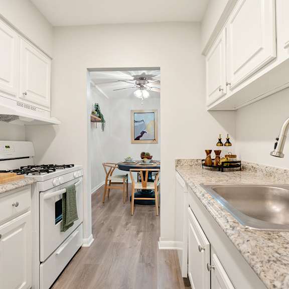 an image of a kitchen with white cabinets and a black sink
